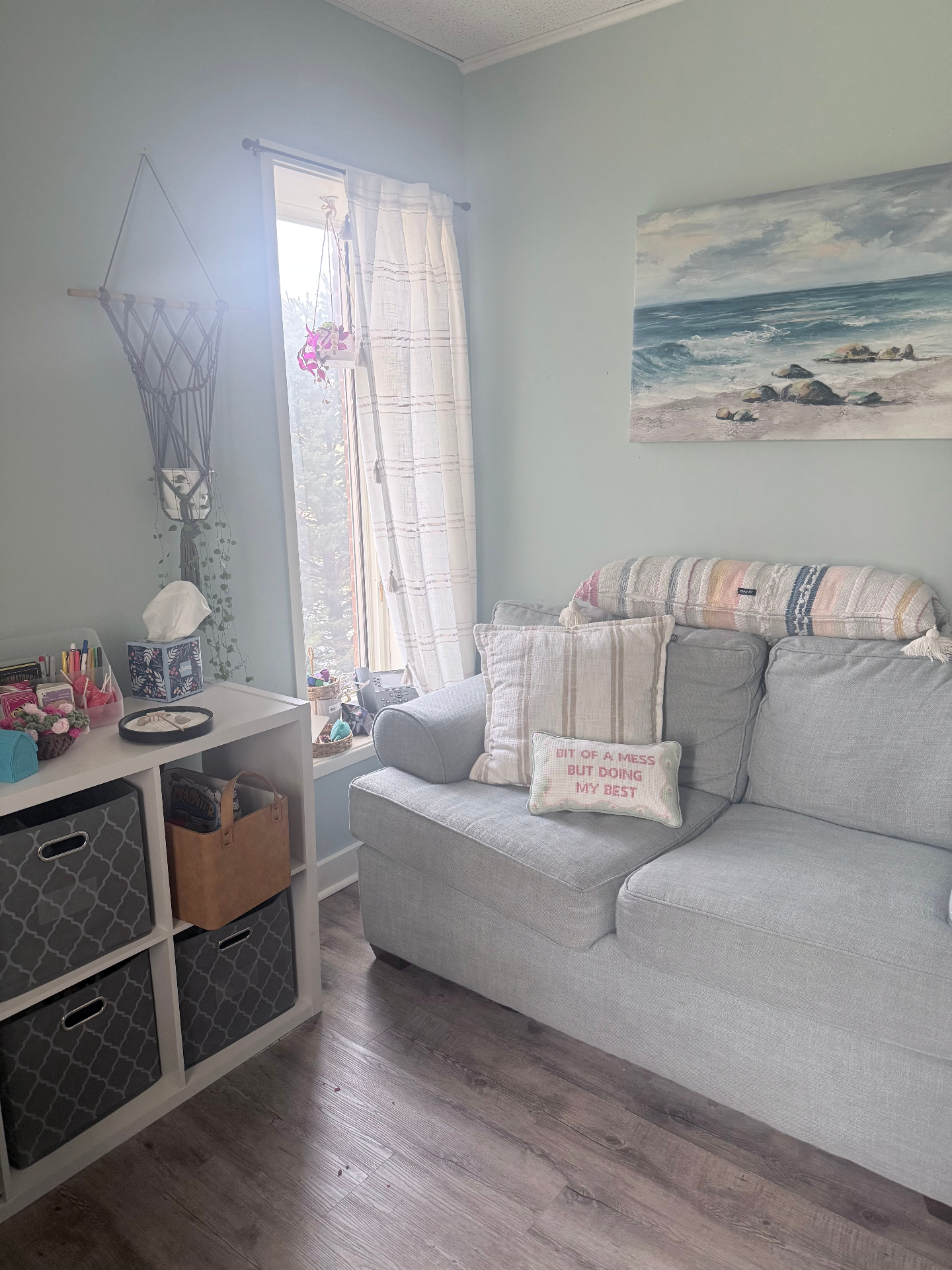 Bright, calming counseling space with a comfortable couch and coastal artwork