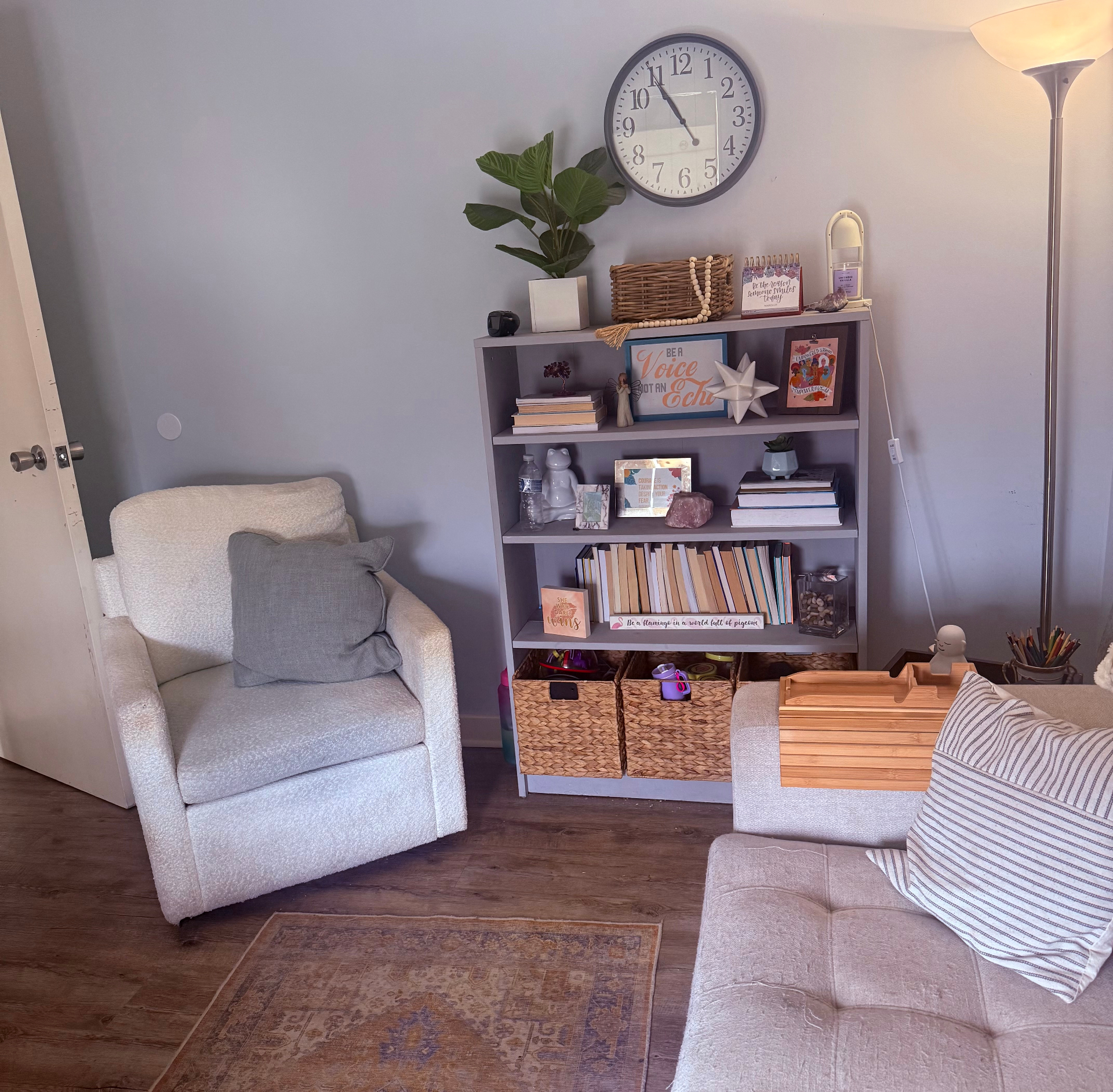 Cozy therapy room with a soft armchair, decorated bookshelf, and warm natural light